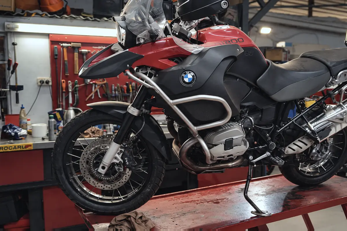 BMW R1200 GS Adventure roja arriba del elevador del taller.